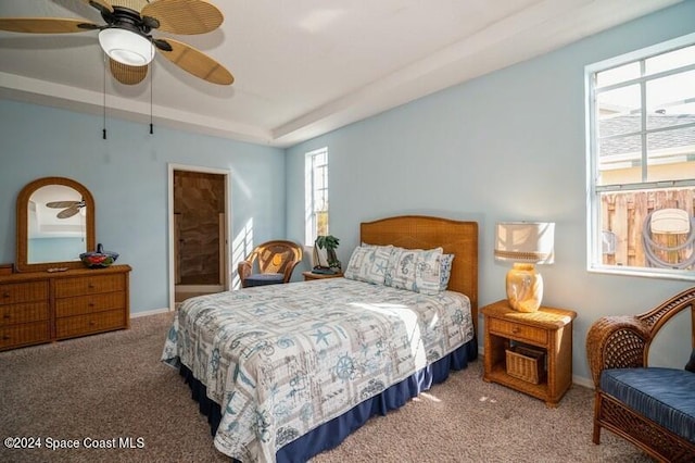 carpeted bedroom featuring ceiling fan and multiple windows