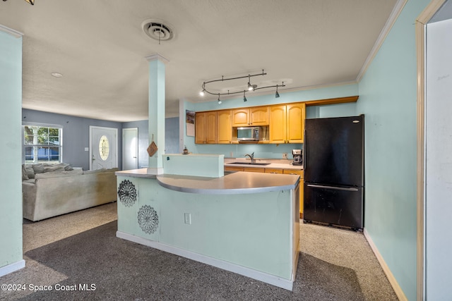 kitchen with black fridge, sink, crown molding, ornate columns, and carpet floors