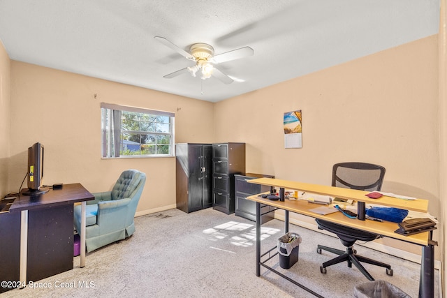 carpeted office space featuring ceiling fan and a textured ceiling