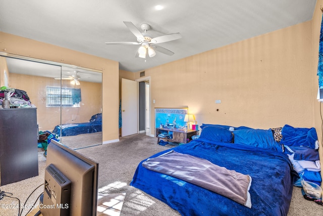 carpeted bedroom with ceiling fan and a closet