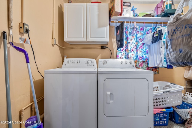 laundry area featuring separate washer and dryer and cabinets