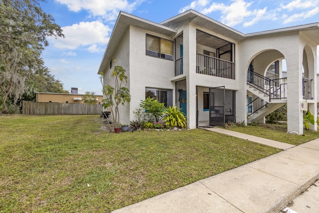 view of front of home with a balcony and a front yard