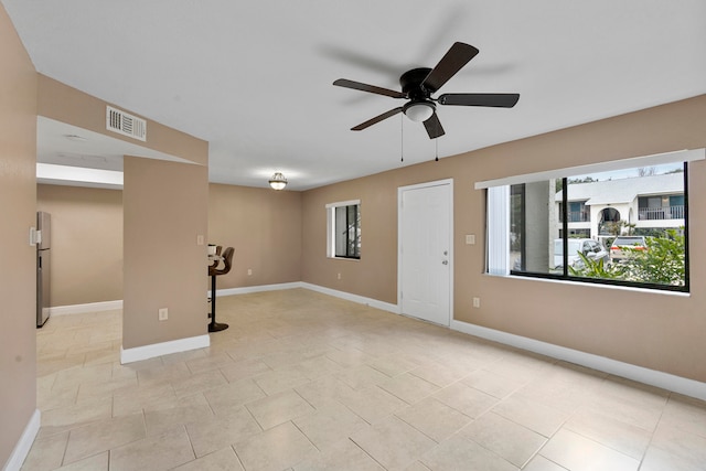 interior space with stainless steel fridge, light tile patterned floors, and ceiling fan