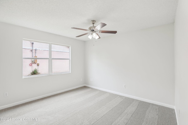 spare room featuring a textured ceiling, carpet flooring, and ceiling fan