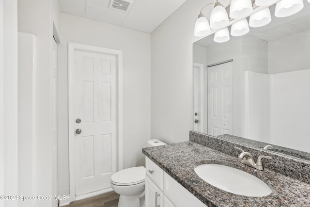 bathroom featuring toilet, hardwood / wood-style flooring, and vanity