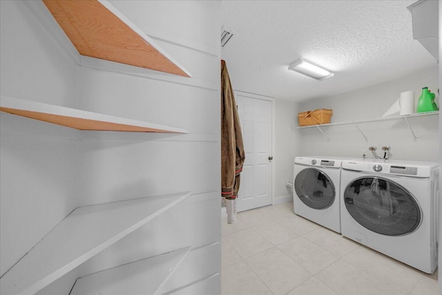 laundry area with a textured ceiling and separate washer and dryer