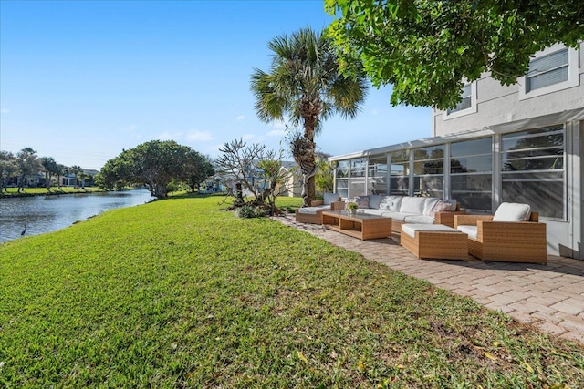 view of yard with outdoor lounge area, a water view, and a sunroom