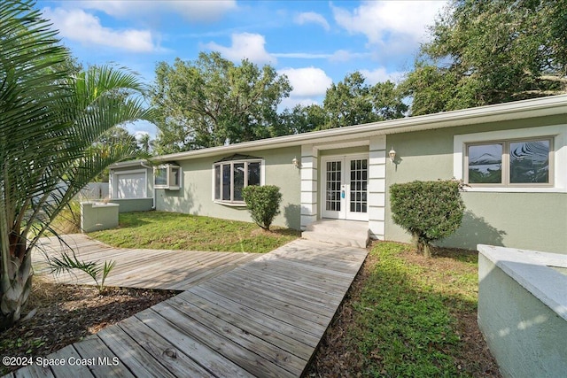 exterior space with french doors, a yard, and a wooden deck