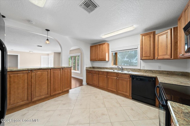 kitchen featuring decorative light fixtures, black appliances, kitchen peninsula, sink, and a textured ceiling