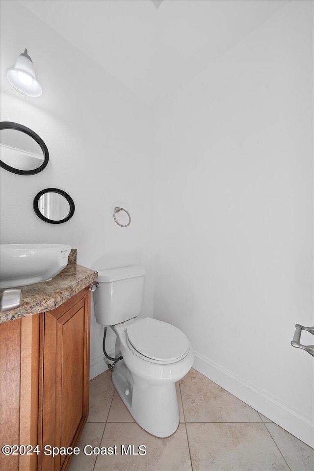 bathroom featuring tile patterned floors, vanity, and toilet