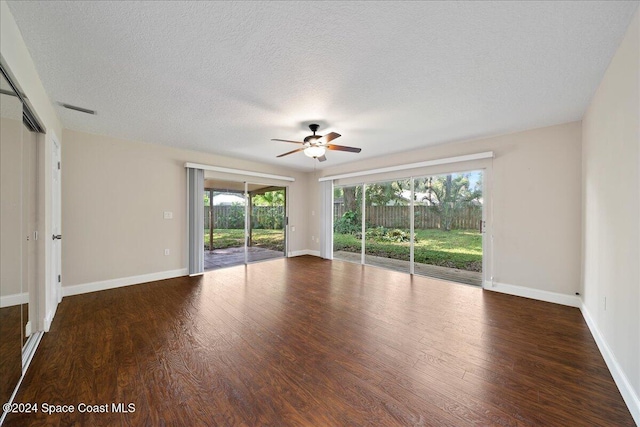 empty room featuring ceiling fan, a textured ceiling, and dark hardwood / wood-style floors