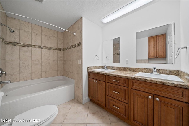 full bathroom featuring toilet, tiled shower / bath, vanity, tile patterned floors, and a textured ceiling