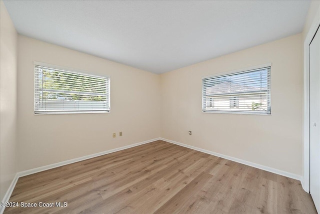 spare room featuring a wealth of natural light and light hardwood / wood-style flooring