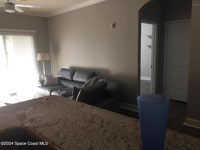 living room with dark hardwood / wood-style floors, ceiling fan, and crown molding