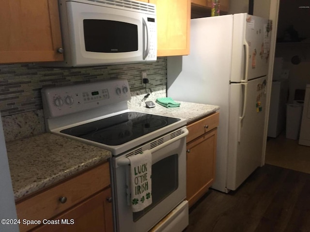 kitchen with decorative backsplash, dark hardwood / wood-style flooring, white appliances, and light stone counters