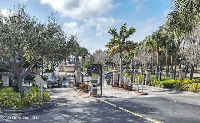 6470 Borasco Dr Unit 1108, Melbourne, FL 32940 - view of asphalt street featuring a gate, traffic signs, curbs, a gated entry, and a residential view