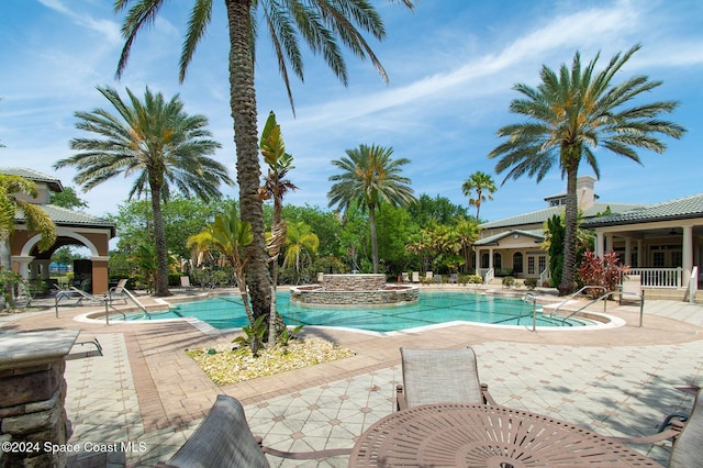 view of swimming pool with a patio and a hot tub