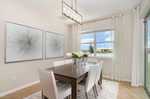 dining room featuring a notable chandelier and light tile patterned floors