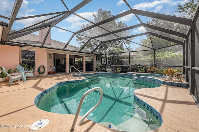 view of pool with a patio, an in ground hot tub, and a lanai