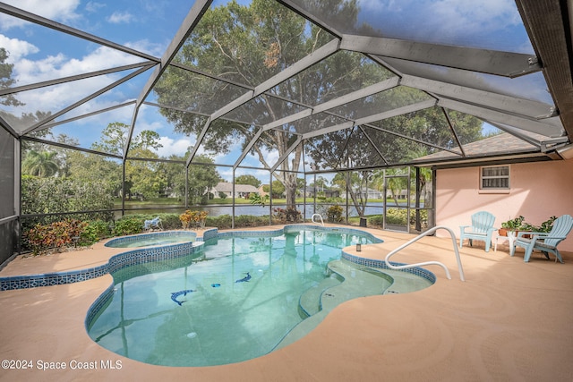 view of pool with a patio area, a lanai, an in ground hot tub, and a water view