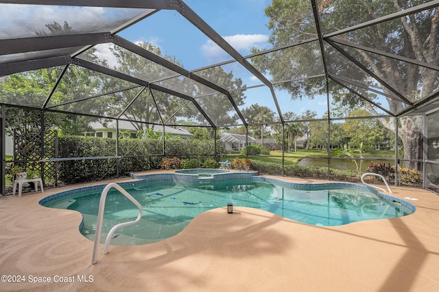 view of pool featuring an in ground hot tub, a patio area, and glass enclosure