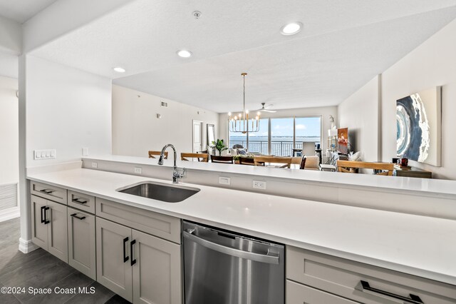 kitchen with stainless steel dishwasher, a notable chandelier, gray cabinetry, and sink