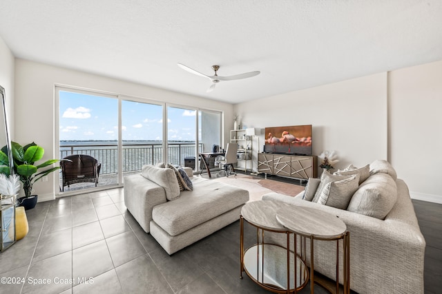 living room featuring tile patterned flooring, ceiling fan, and a healthy amount of sunlight