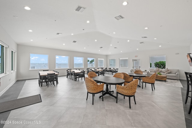 dining area featuring light tile patterned flooring and vaulted ceiling