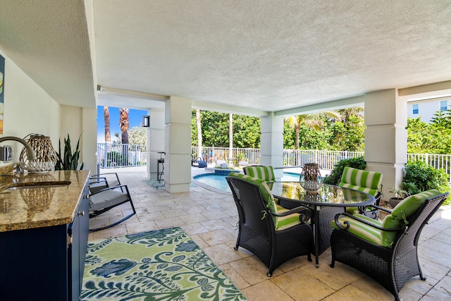 view of patio / terrace featuring a fenced in pool and sink