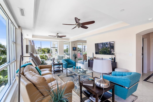 living room with ceiling fan, crown molding, and a tray ceiling