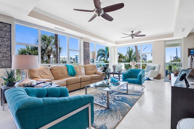 living room with a tray ceiling and ceiling fan