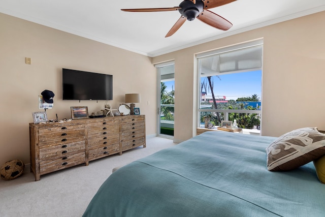 carpeted bedroom featuring crown molding and ceiling fan