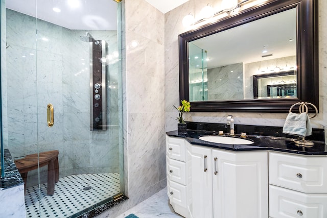 bathroom with tile walls, vanity, and a shower with shower door