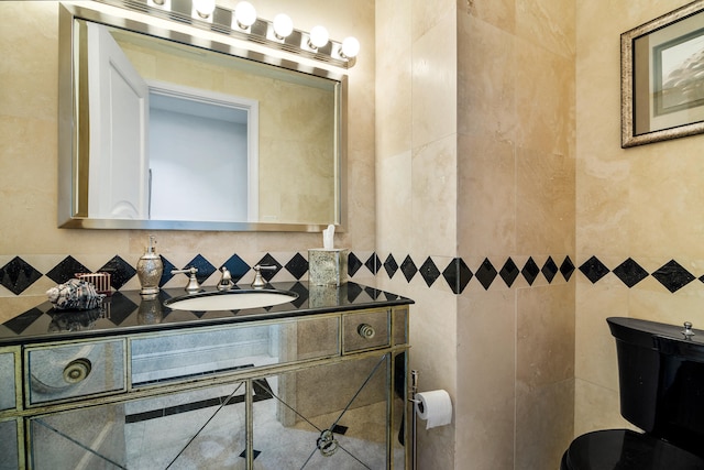 bathroom with tile walls, vanity, and toilet