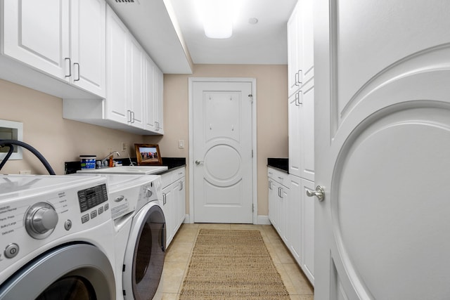 laundry area featuring sink, washer and clothes dryer, light tile patterned flooring, and cabinets