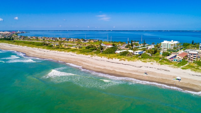 drone / aerial view featuring a water view and a view of the beach