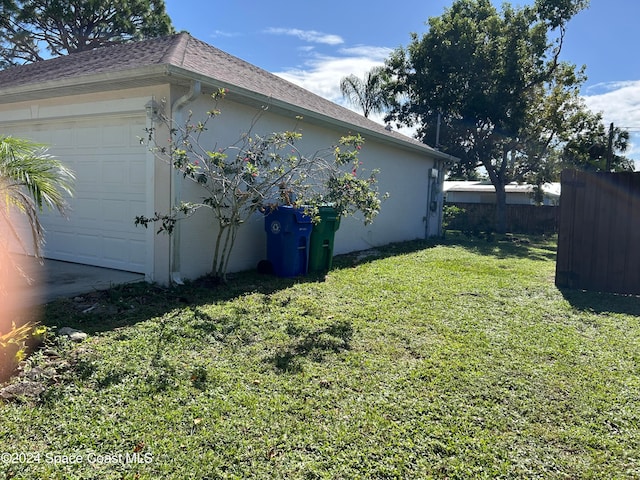 view of property exterior with a garage and a lawn