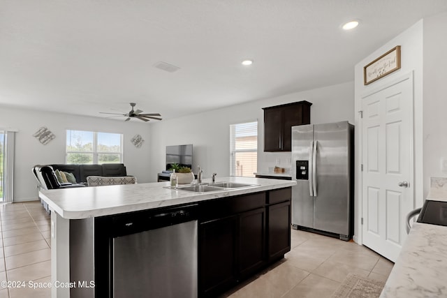 kitchen with a center island with sink, appliances with stainless steel finishes, light tile patterned floors, sink, and ceiling fan