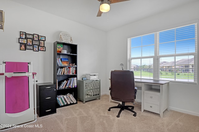 carpeted home office featuring ceiling fan