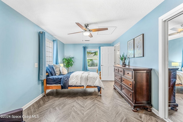 bedroom featuring a textured ceiling, light parquet floors, and ceiling fan