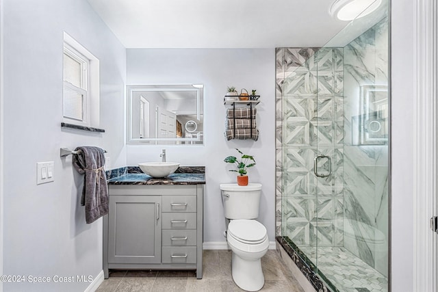 bathroom featuring toilet, a shower with shower door, vanity, and tile patterned flooring