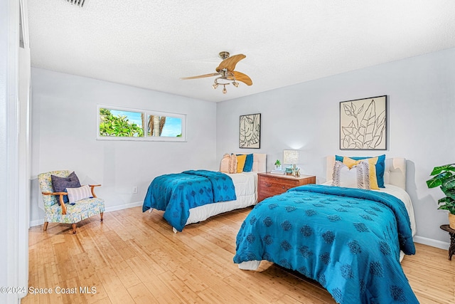 bedroom featuring ceiling fan, a textured ceiling, and hardwood / wood-style floors