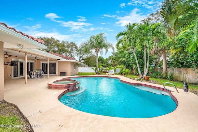 view of swimming pool with an in ground hot tub, a patio area, and ceiling fan