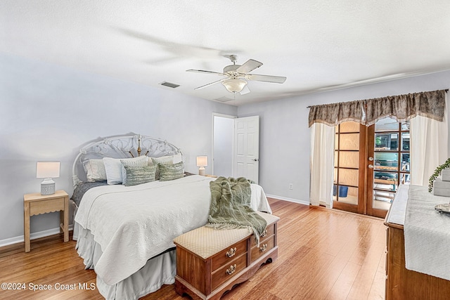 bedroom featuring light hardwood / wood-style floors, a textured ceiling, and ceiling fan