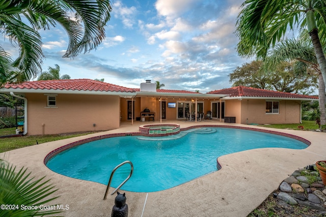 view of swimming pool with an in ground hot tub, a grill, and a patio