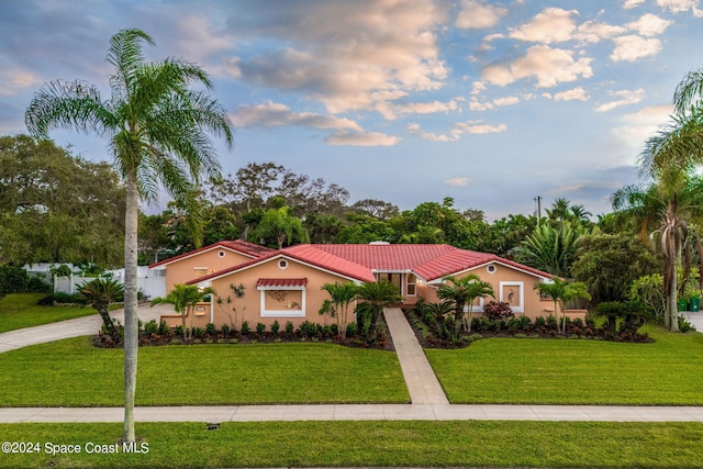 mediterranean / spanish home with a front lawn