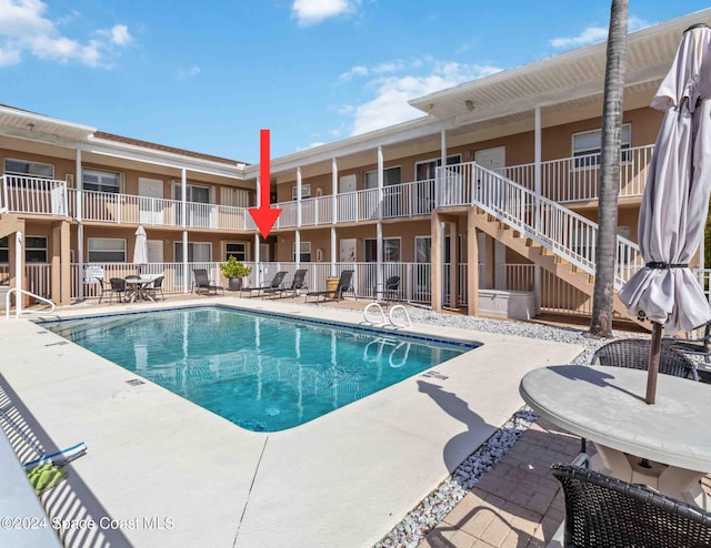 view of swimming pool featuring stairs, a patio area, and fence