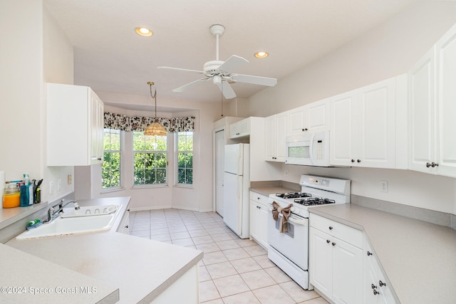 kitchen with white appliances, sink, ceiling fan, pendant lighting, and white cabinets