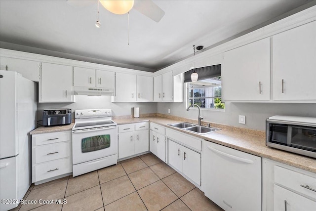 kitchen featuring white appliances, sink, light tile patterned floors, decorative light fixtures, and white cabinetry