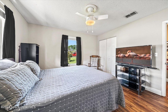 bedroom featuring a closet, ceiling fan, dark hardwood / wood-style flooring, and a textured ceiling